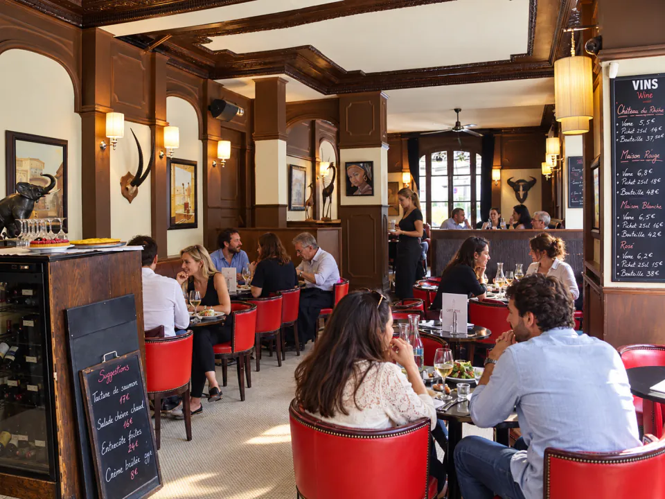 La salle du Café Ribe, ses boiseries et ses banquettes de cuir rouge